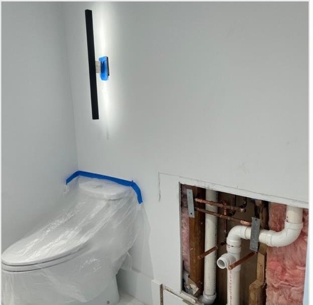 Bathroom wall opened for plumbing access