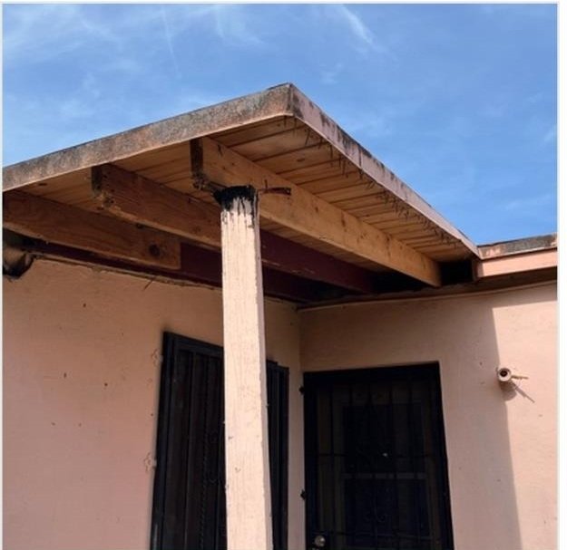 Damaged patio roof framing before repair